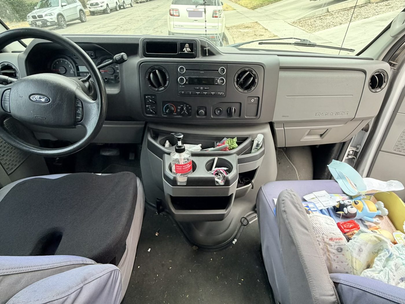 Van interior before detailing, cluttered console and dusty seats